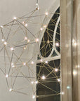 Geometric light fixture with string lights on a wall